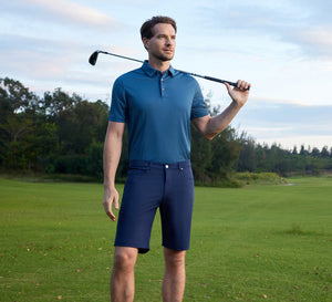 Model carrying a golf club over the shoulder, wearing the Your Favorite Jacquard Polo and 4-way Stretch Performance Solid Shorts on the golf course.