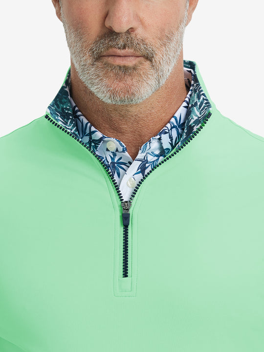 Close-up from nose to chest, showing collar and zipper detail of the light green golf pullover.