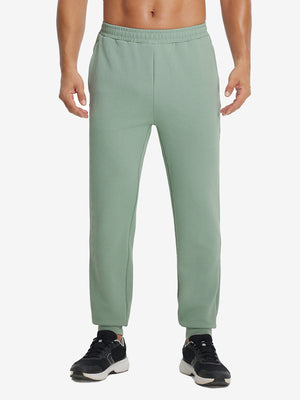Front lower body view of model wearing soft sweatpants with 4 zipper pockets in beryl green