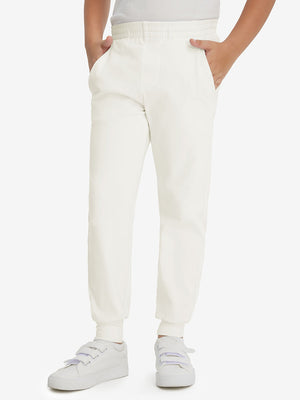 Model wearing beige fleece stretch water resistant boys joggers, front view showing lower body and pants.