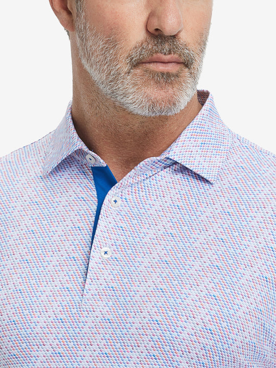 Close-up from nose to chest, showing collar and fabric pattern detail of the colourful hexagon polo shirt.
