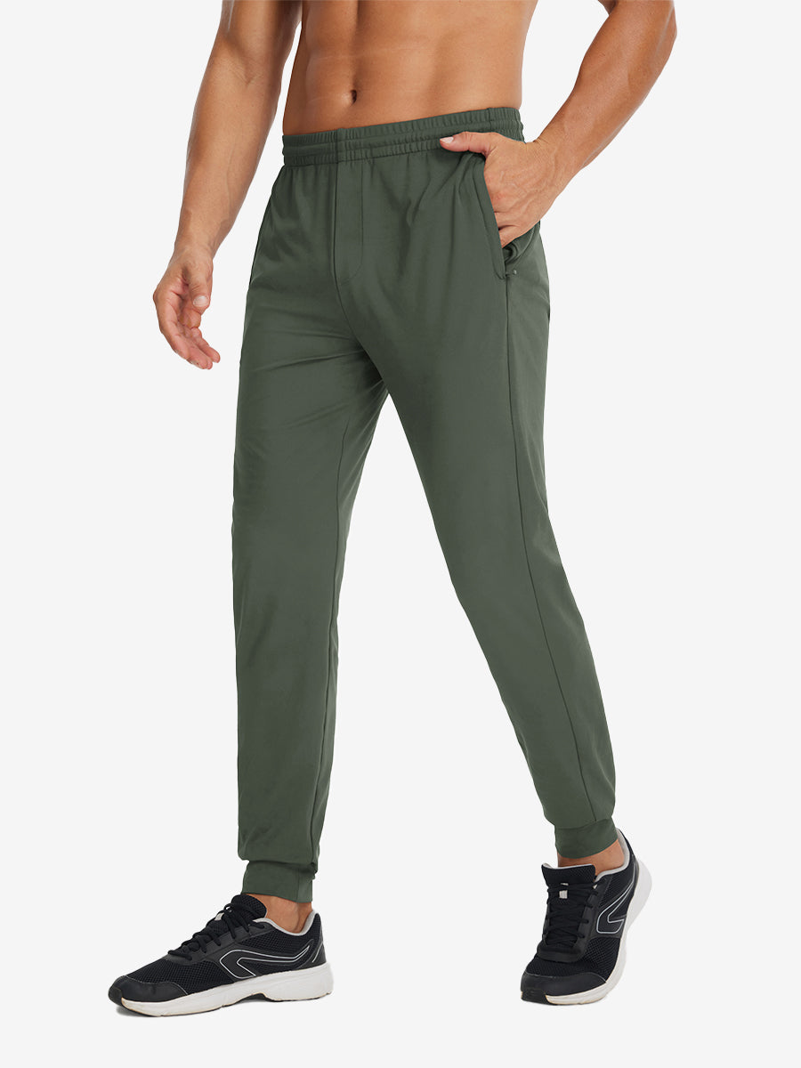 Side view of model with hand in pocket wearing lightweight traning track pants in olive green.