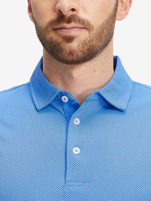 Close-up of a model wearing the plum blue feather weight jacquard polo shirts, focusing on the collar and face