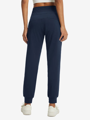 Model wearing women's stretch fleece lined water resistant joggers in navy, showing the back lower body view.