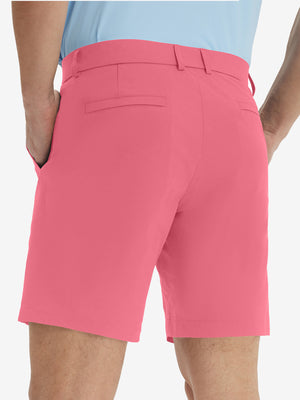 Back lower body view of model wearing the peach pink stretch soft flat front dress golf shorts, highlighting the rear design