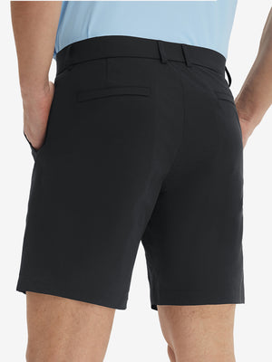 Back lower body view of model wearing the black stretch soft flat front dress golf shorts, highlighting the rear design