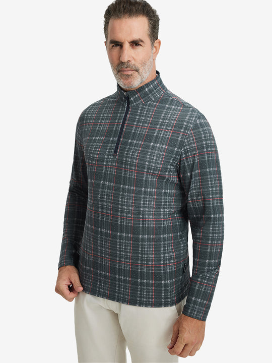 Front upper body view of model standing in retro black/red plaid full print quarter zip pullover, relaxed look.