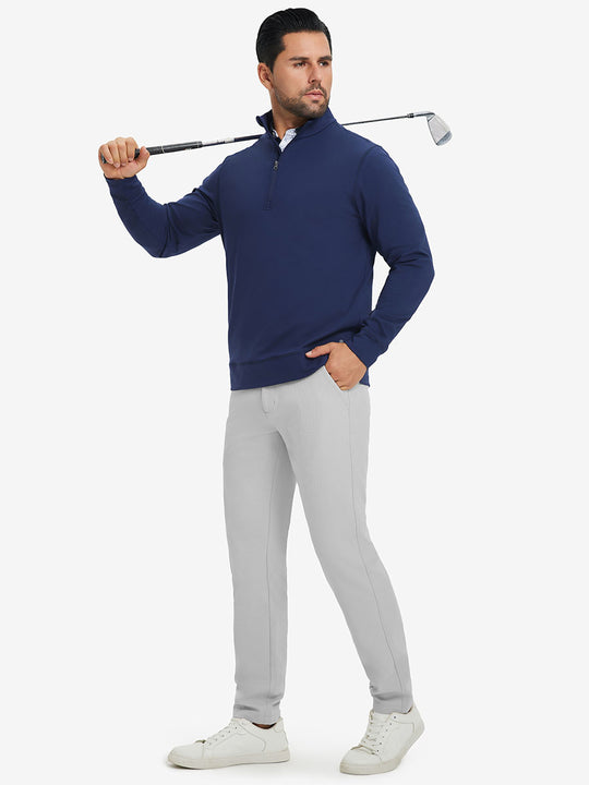 Model in dark blue top holding golf club on shoulder wearing lightweight moisture wicking dress pants in silver grey.
