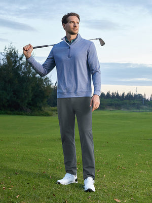 Model holding a golf club on course, wearing stretch plain everyday pants in dark grey