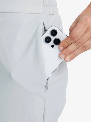 Detail shot of front side pocket holding an iPhone in GLACIER GREY Women's 7/8 Ankle Golf Track Pants.