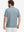 Back half-body of model in blue abstract stretch printed collarless henley golf shirts