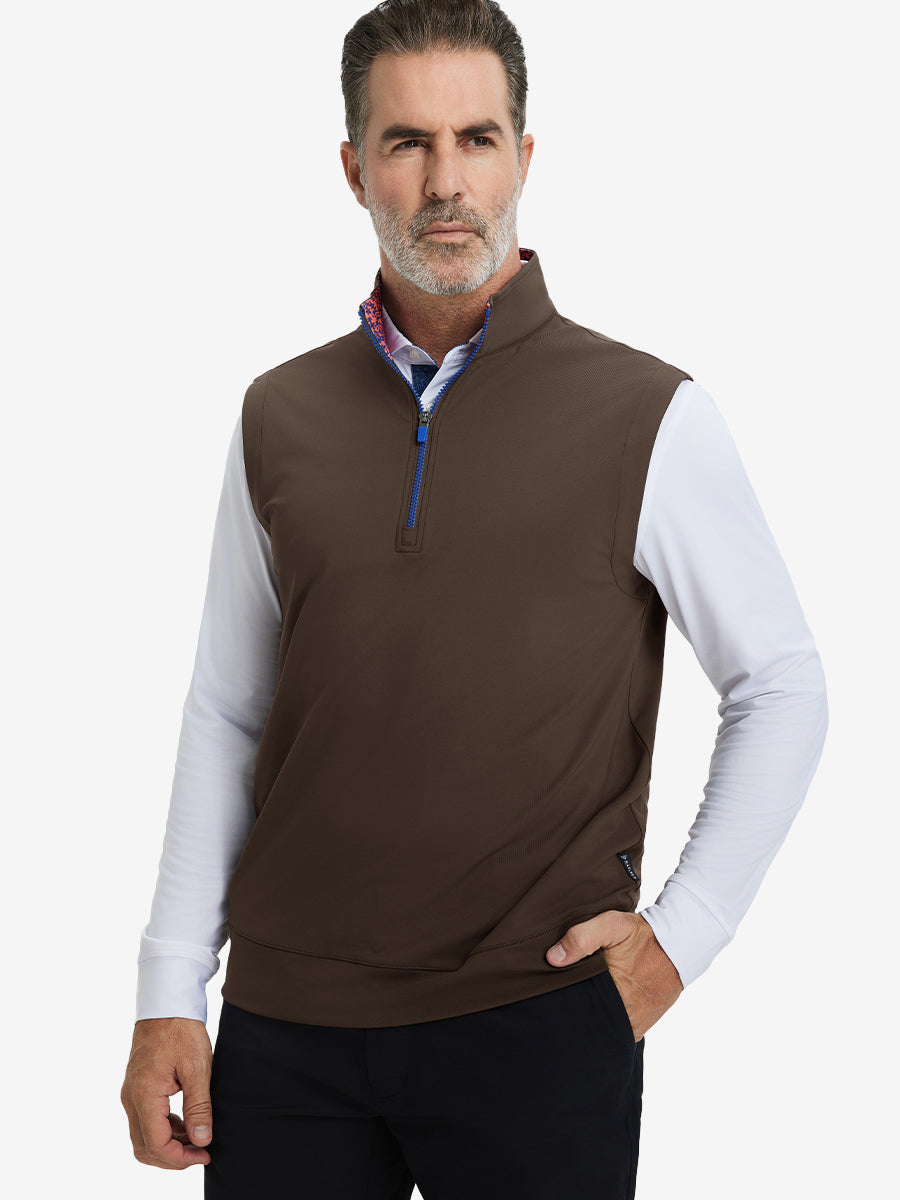 Model with hands in pockets, wearing print collar quarter zip golf vest in coffee brown, casual look.