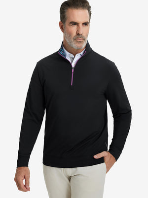 Front upper body view of model wearing lightweight golf quarter zip pullover in black, relaxed fit.