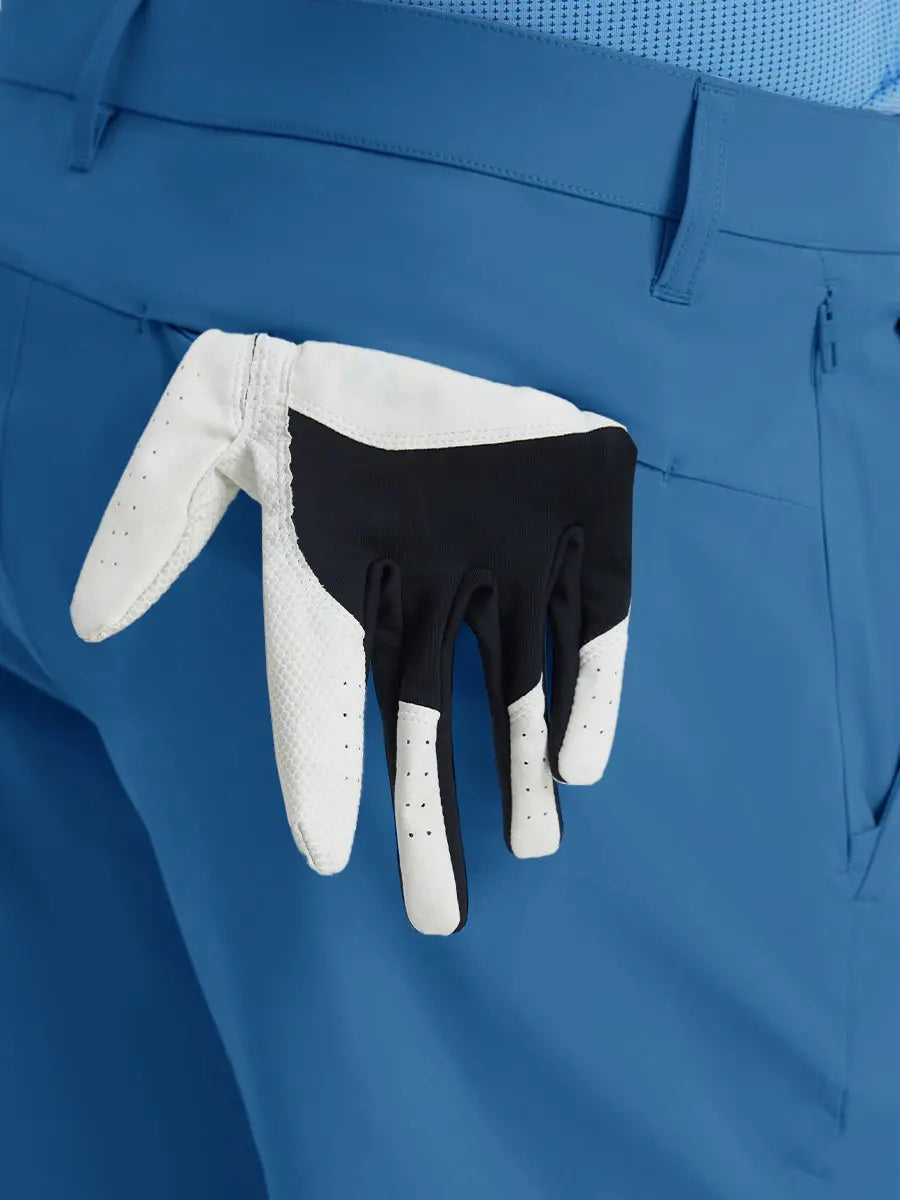 Back view of Player Fit Versatile Solid Shorts 9 Inch with golf glove tucked into right pocket – BLUE