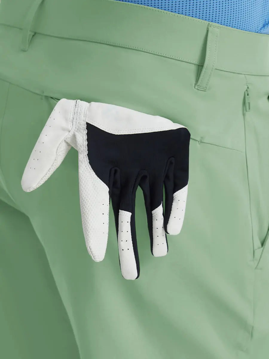 Back view of Player Fit Versatile Solid Shorts 9 Inch with golf glove tucked into right pocket – BERYL GREEN