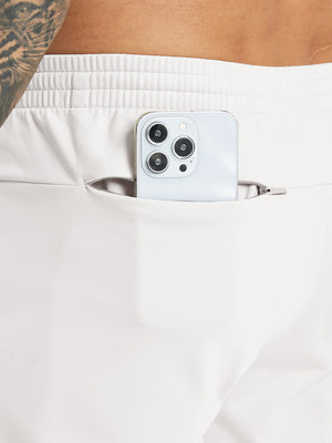 Back pocket detail of Water Resistant Comfy Fleece Golf Joggers in oyster grey, holding smartphone