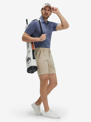 Full-body shot of model carring a golf bag in light dark blue grid ultra-light quick dry moisture wicking collared polo shirt