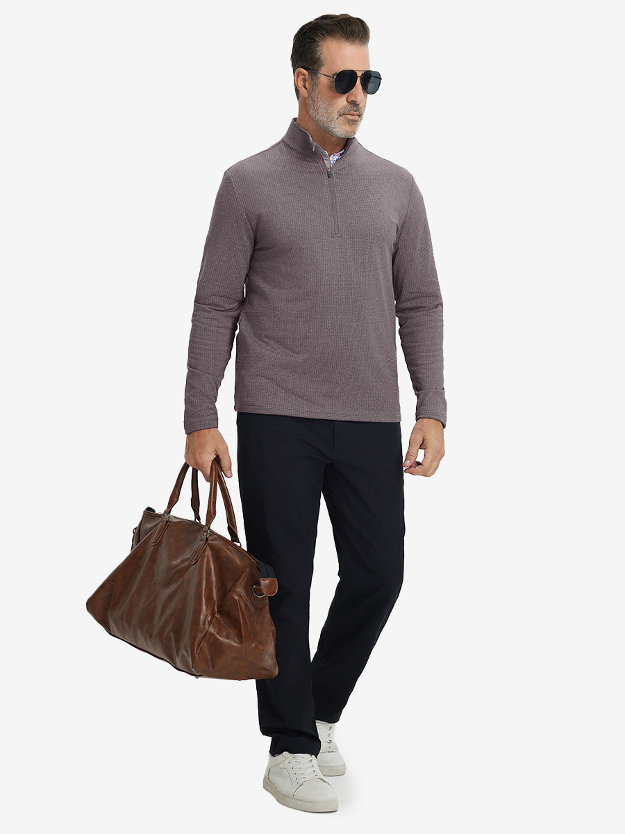 Model holding briefcase, dressed in casual fleece lined quarter zip pullover in drak red, full-body view.
