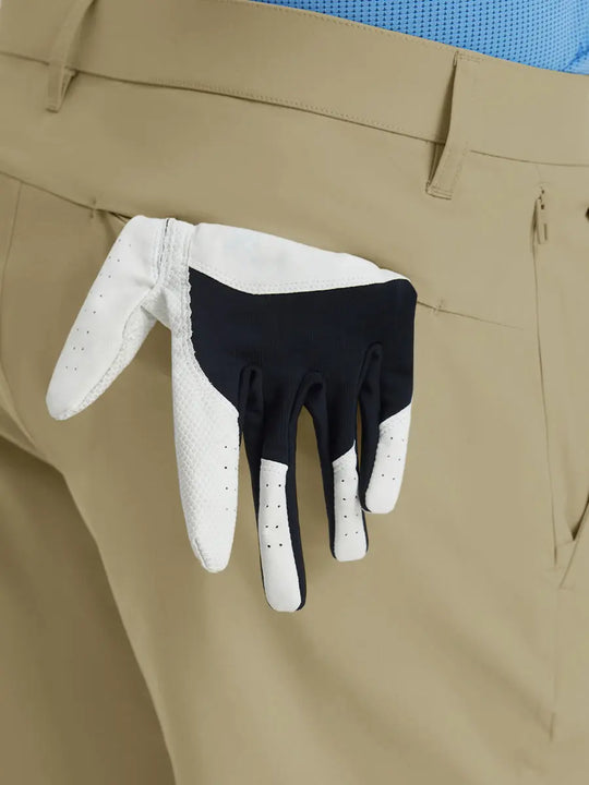 Back view of Player Fit Versatile Solid Shorts 7 Inch with golf glove tucked into right pocket – KHAKI