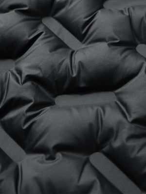 Fabric close-up of boys windproof puffer jacket with pockets, highlighting texture and finish in black.