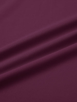 Close-up of bordeaux red long sleeve solid jersey polo fabric texture showing soft knit and smooth finish details.