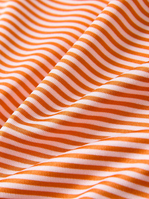 Close-up of orange stripe performance cooling polo - youth fabric texture.