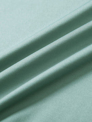 Close-up of beryl green long sleeve solid jersey polo fabric texture showing soft knit and smooth finish details.