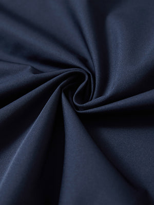 Detail of the lightweight water-repellent softshell hooded jacket in navy, fabric twisted into a spiral roll.