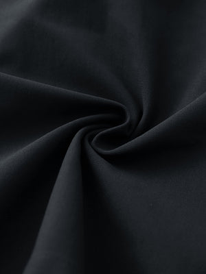 Close-up fabric detail of 4-way stretch performance solid shorts, smooth texture with flexible black feel