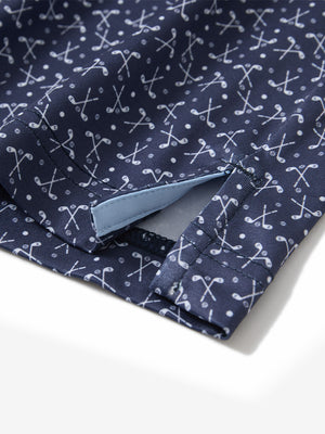 Close-up of the hem vent on the dark blue golf club 4 way stretch print collared polo shirt, showing the side split for movement