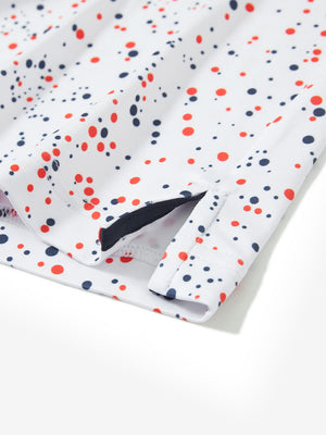 Close-up of the hem vent on the white polka dots 4 way stretch print collared polo shirt, showing the side split for movement