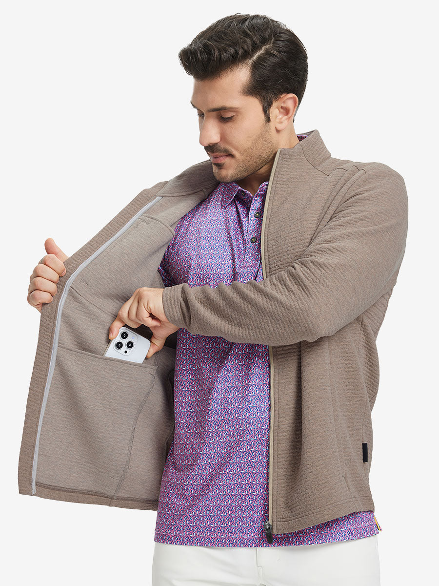 Model front half body lifting jacket, hand in inner pocket, textured insulated winter jacket, light brown heather.