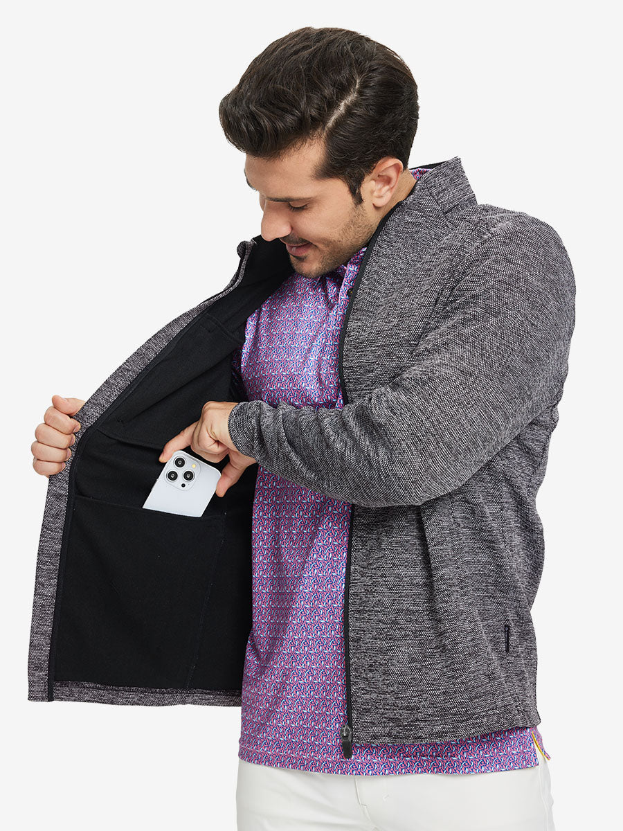 Model front half body lifting jacket, hand in inner pocket, textured insulated winter jacket, black heather.