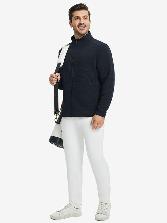 Full body shot, model carrying golf bag in textured insulated winter jacket, active outdoor style, navy.