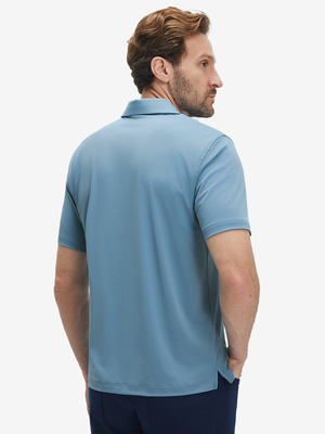 Back half-body view of a model wearing the misty blue everyday classic solid polo, highlighting the tailored rear fit