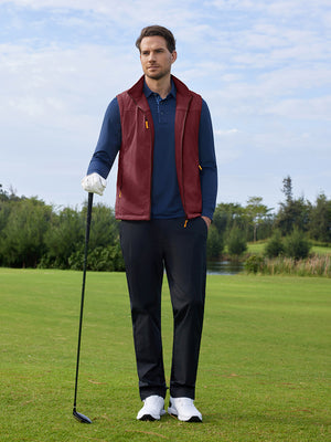 A model holding a golf club is photographed in a full-body shot, wearing a maroon windproof fleece reversible golf vest.